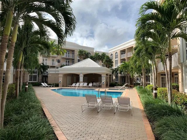 a view of a patio with table and chairs under an umbrella with a fire pit