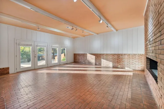 a view of empty room with wooden floor and fireplace