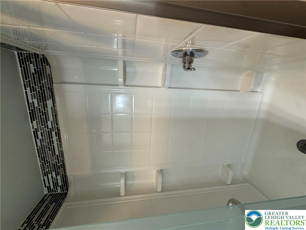134 Bear Road Kunkletown, PA 18058 - Photo 29 of 42 A tiled tub surround features integrated shelving and custom accent tile details.