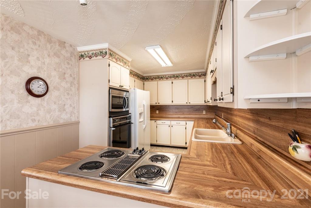 307 Kirkpatrick Road Taylorsville, NC 28681 - Photo 17 of 39 a kitchen with granite countertop a stove and white cabinets