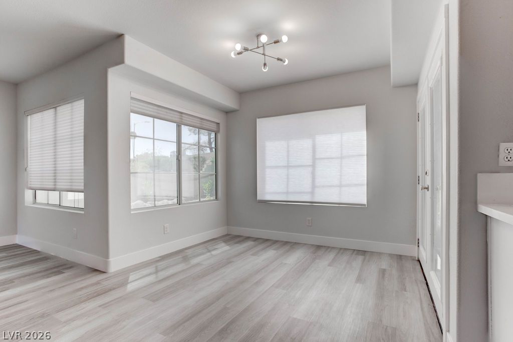 1 Rising Sun Court Henderson, NV 89074 - Photo 13 of 47 Luminous living space showcases contemporary lighting and expansive windows, all complemented by sleek, modern flooring.
