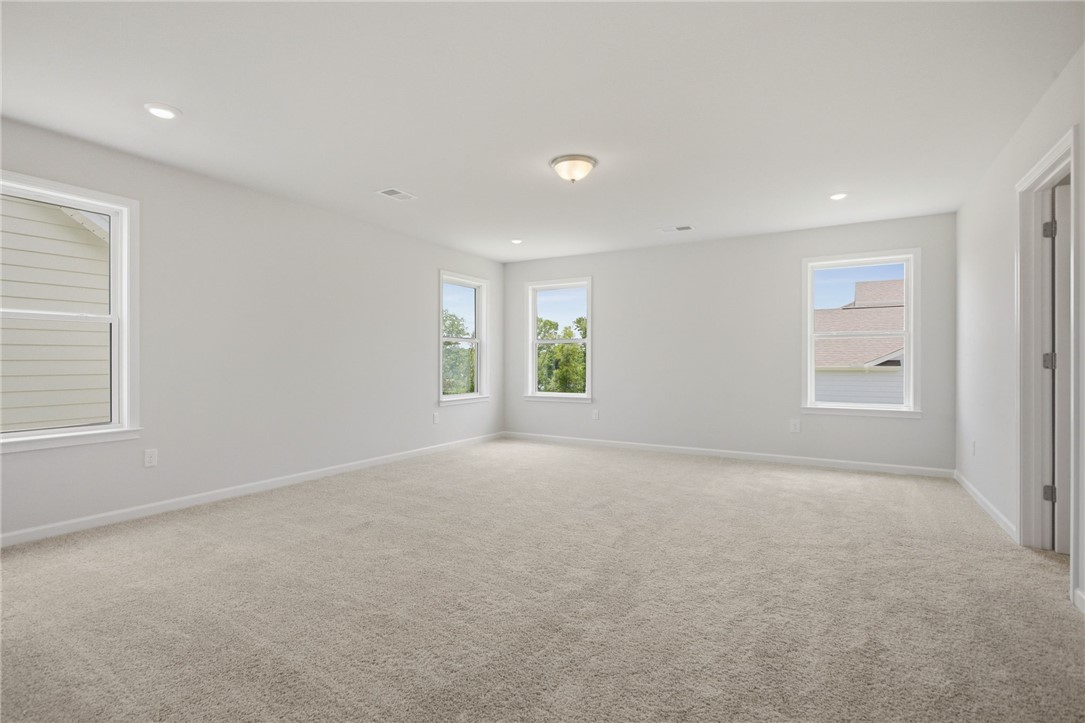 557 Hydrangea Street, Unit LOT 46 Seneca, SC 29678 - Photo 20 of 37 A generously sized room with neutral carpet and ample natural illumination from multiple windows.