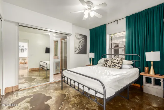 a bedroom with a large bed a chandelier and a dresser