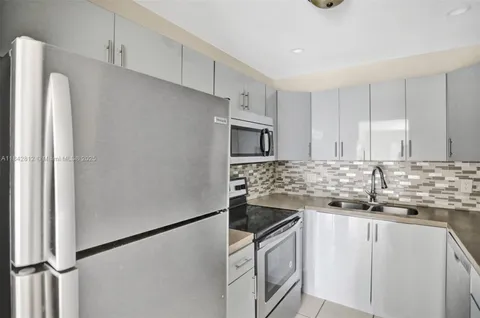 a kitchen with stainless steel appliances granite countertop a refrigerator sink and stove