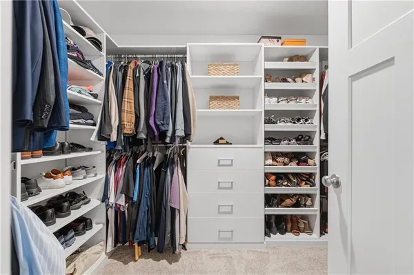 a view of walk in closet with clothes and shoes