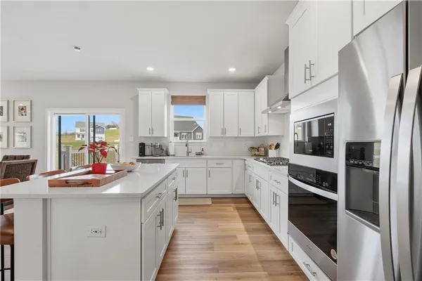 a kitchen with stainless steel appliances a refrigerator sink and white cabinets