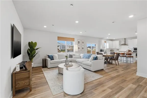 a living room with furniture a wooden floor and a flat screen tv