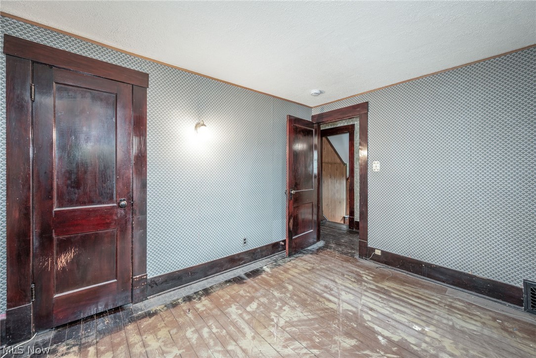 267 West Riddle Avenue Ravenna, OH 44266 - Photo 14 of 47 Patterned wall covering, dark wood trim, wood-finish flooring, and wall-mounted light fixture