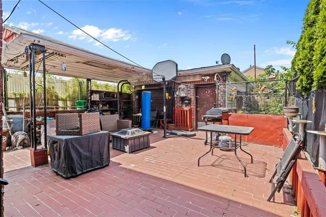 a view of a patio with dining table and chairs with a barbeque grill and plants