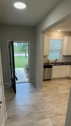 an empty room with wooden floor and natural light