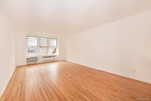 a view of a room with wooden floor and window