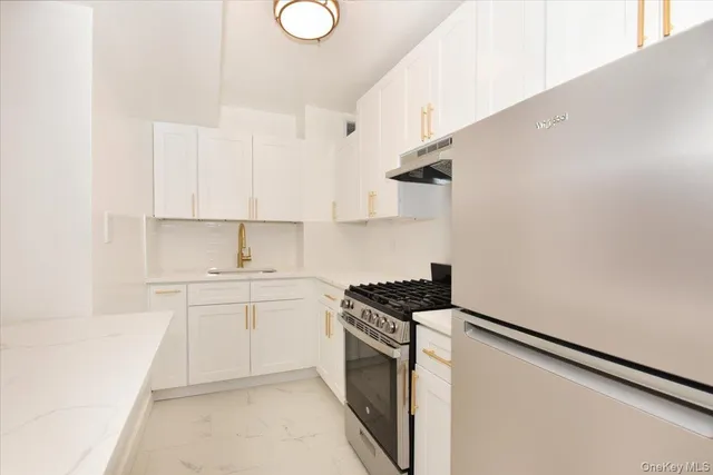 a kitchen with stainless steel appliances white cabinets and a sink