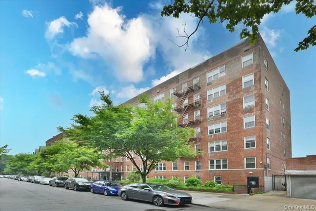 a couple of cars parked in front of brick building