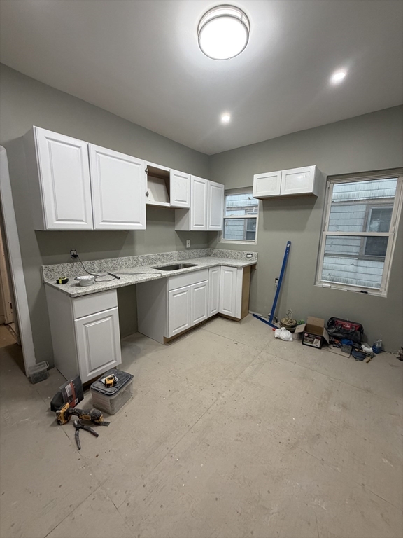 a kitchen with a sink a stove cabinets and counter space