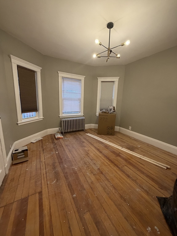 3943 Washington Street, Unit 1 Boston, MA 02131 - Photo 3 of 8 a view of empty room with wooden floor and fan