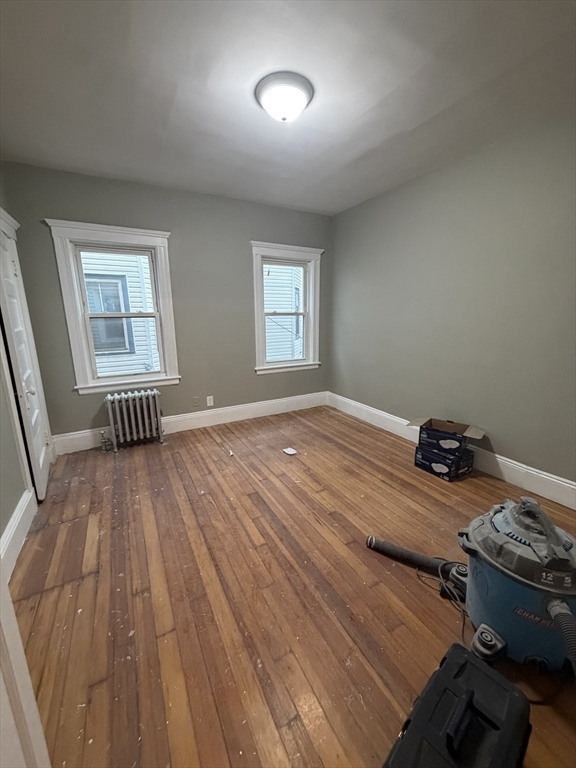 3943 Washington Street, Unit 1 Boston, MA 02131 - Photo 5 of 8 a bedroom with a bed and wooden floor