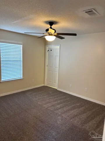 a view of an empty room with a ceiling fan