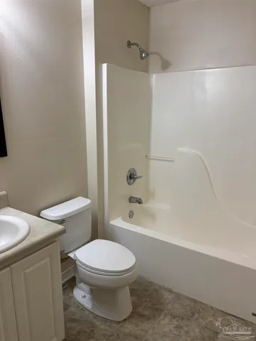 a white toilet and tub sitting next to a bathroom sink