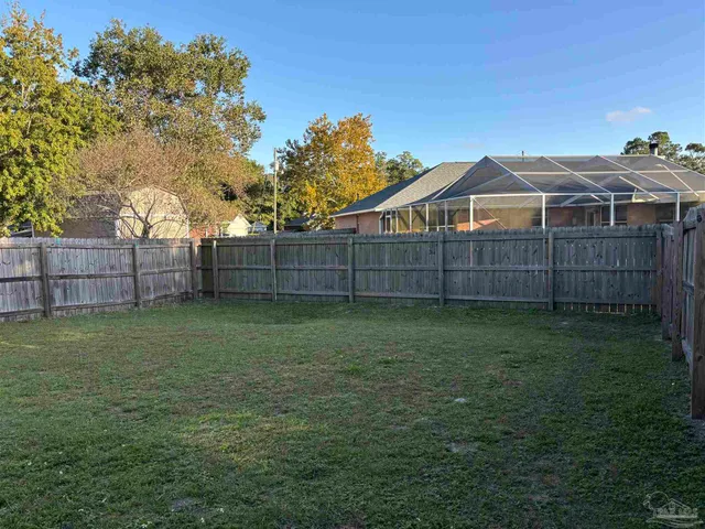 a view of a backyard with a garden and wooden fence