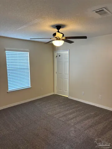 a view of an empty room with a ceiling fan