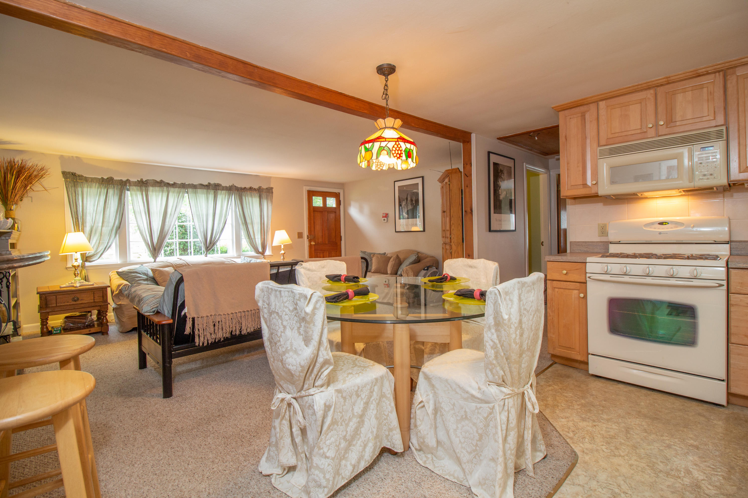 52 Farm Hill Road Centerville, MA 02632 - Photo 10 of 29 a living room with furniture a fireplace and a dining table with kitchen view