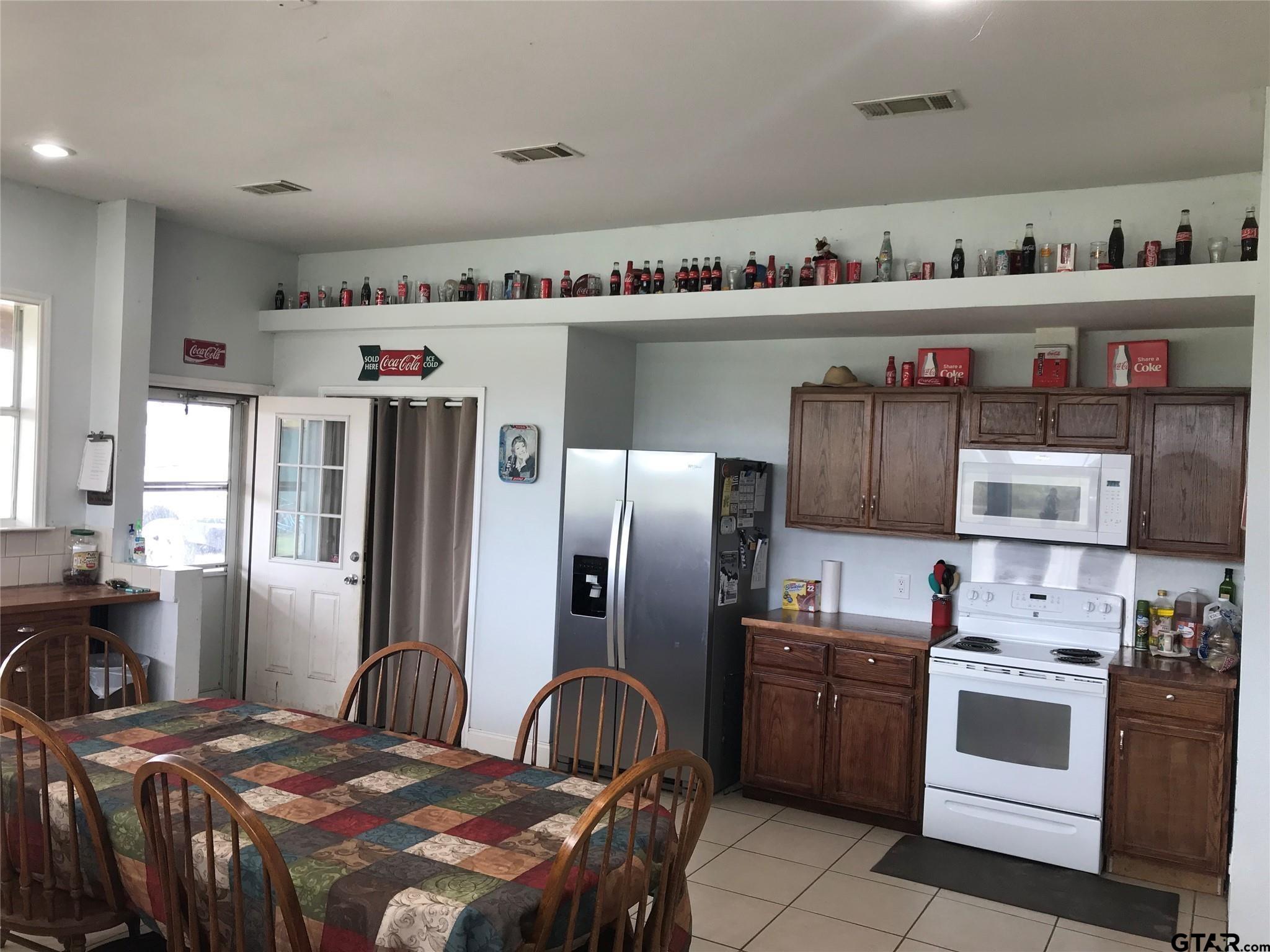 1100 East Rabbit Cove Road Quinlan, TX 75474 - Photo 2 of 18 a kitchen with stainless steel appliances a refrigerator a sink and a stove