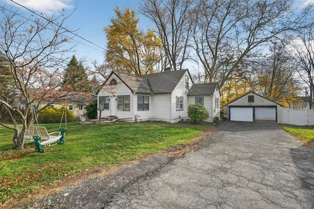 a view of a house with a yard and large trees