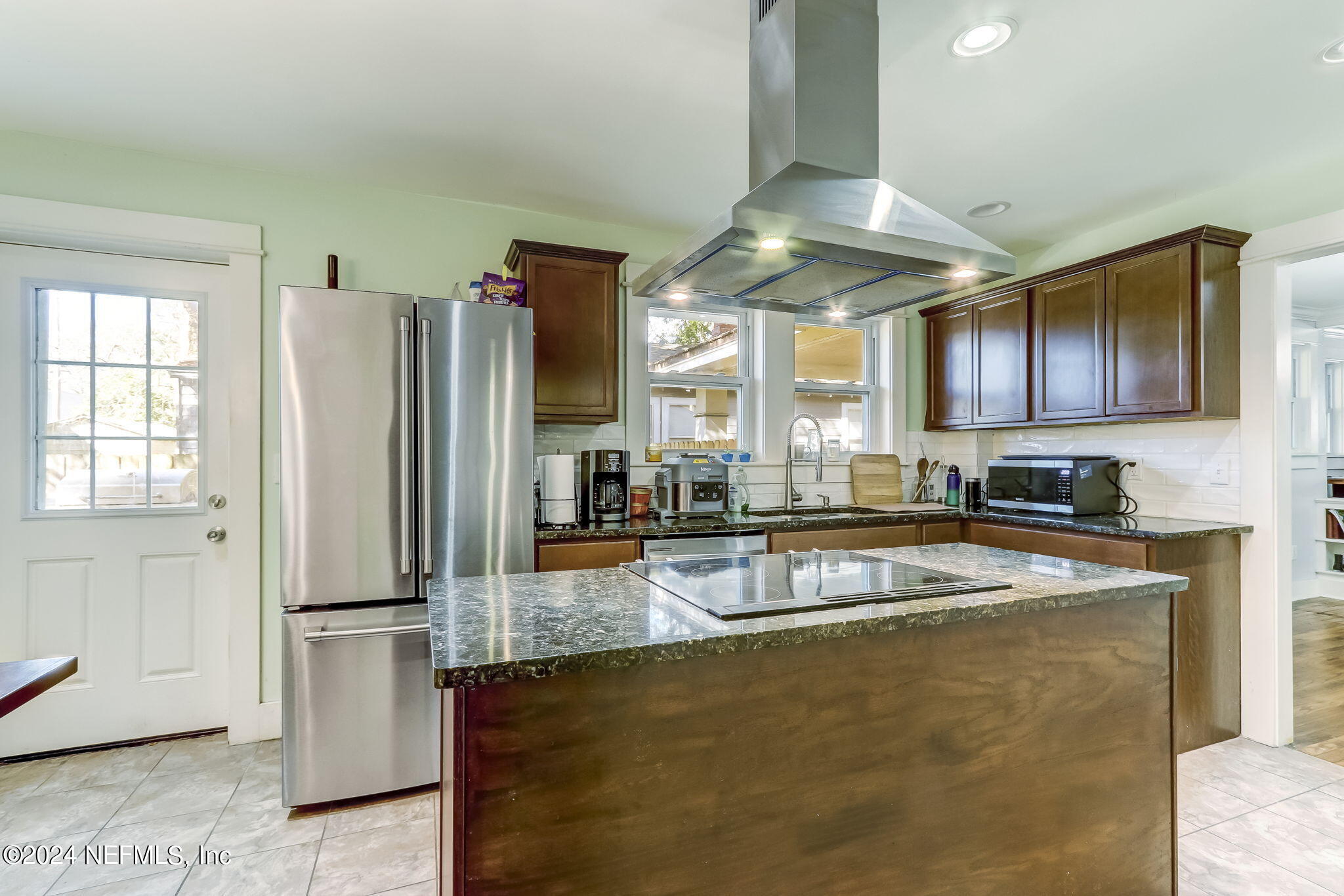 a view of a kitchen with stainless steel appliances granite countertop a refrigerator a stove and a sink