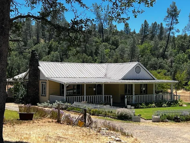 a front view of a house with a yard and potted plants