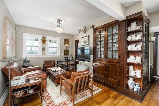 a living room with furniture a bookshelf and a window