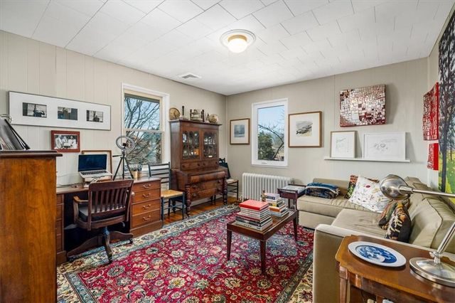 a living room with furniture a piano and a bookshelf