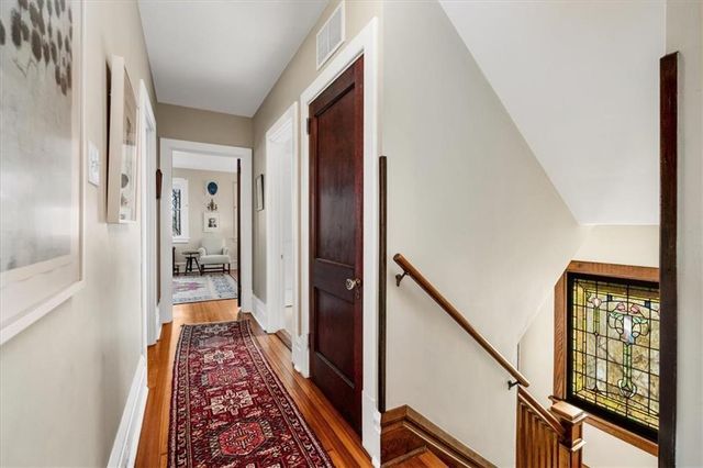 a view of a hallway with wooden floor and staircase