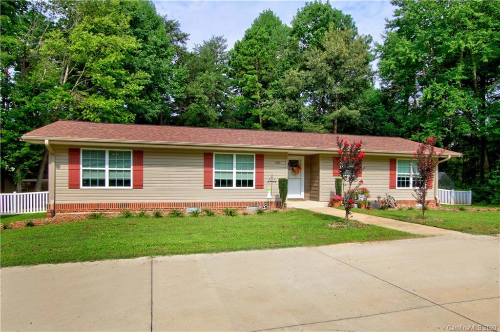 a front view of a house with a yard and trees
