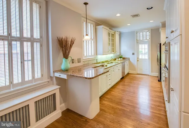 a bathroom with a granite countertop sink and a large mirror