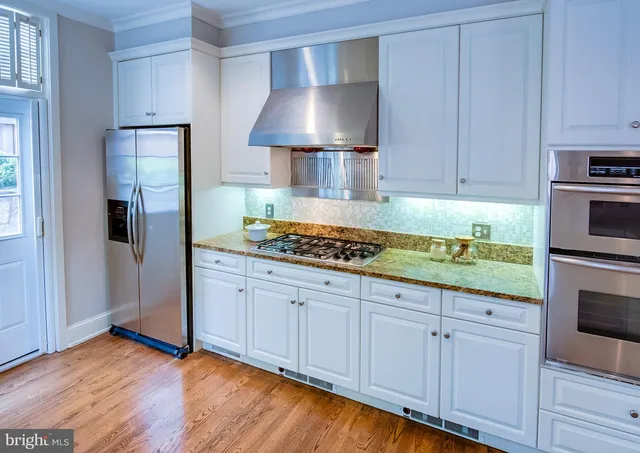 a kitchen with granite countertop a stove and a wooden cabinets