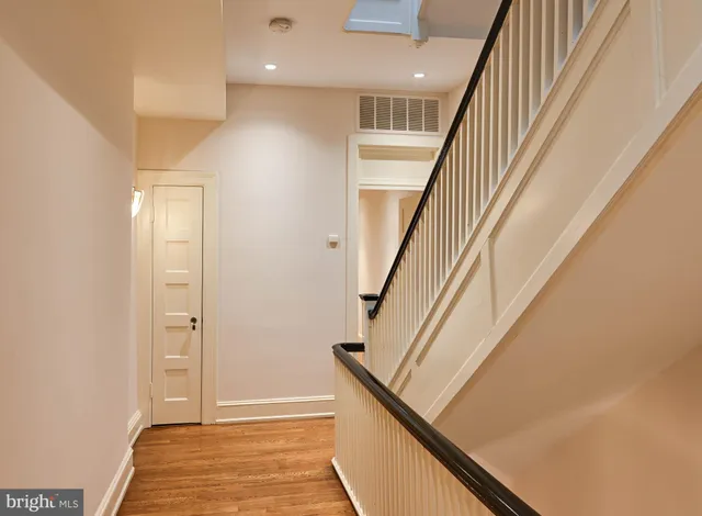 a view of a hallway with wooden floor and staircase