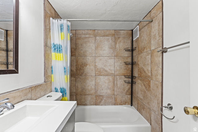 180 South 300 East Logan, UT 84321 - Photo 13 of 35 Full bath with vanity, shower / bathtub combination with curtain, and a textured ceiling