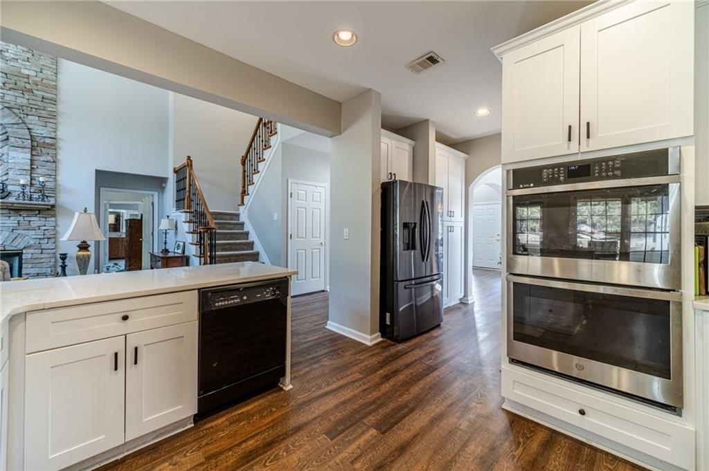 4335 Lakeside Boulevard Monroe, GA 30655 - Photo 19 of 66 a kitchen with stainless steel appliances a stove a microwave and a hard wood floors