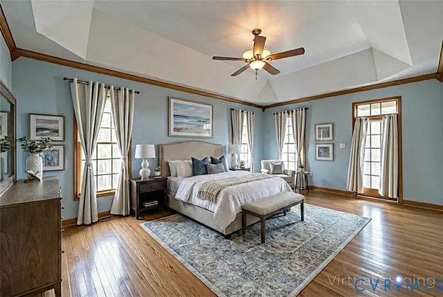 a spacious bedroom with a bed wooden floor and window