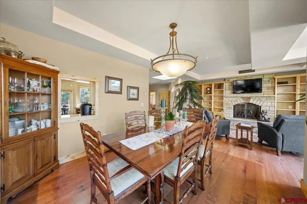 a view of a dining room with furniture a kitchen and chandelier