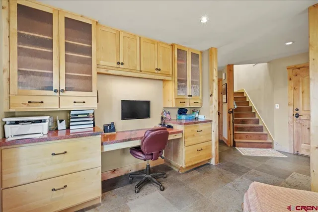 a view of a workspace with furniture and a window