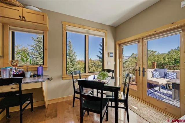 a view of a dining room with furniture large windows and wooden floor