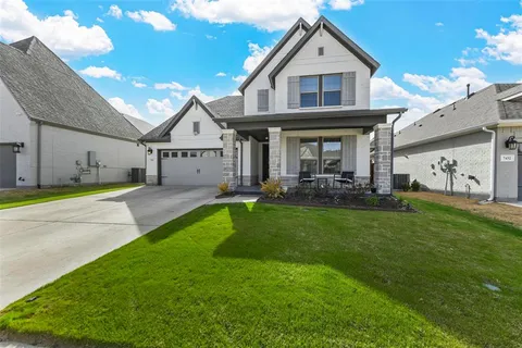 a front view of a house with a garden and yard