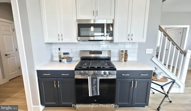 a kitchen with stainless steel appliances a stove a microwave and cabinets