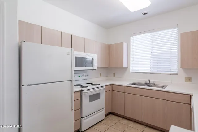a kitchen with cabinets appliances a sink and a window