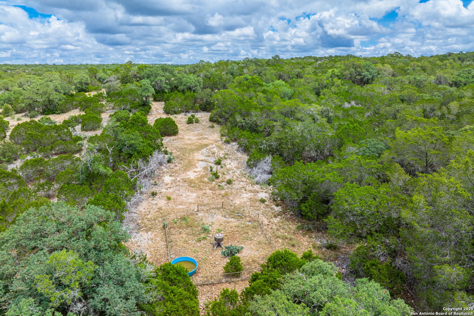 485 Mitchell Ranch Road Camp Wood, TX 78833 - Photo 14 of 47 a view of a garden with a building in the background