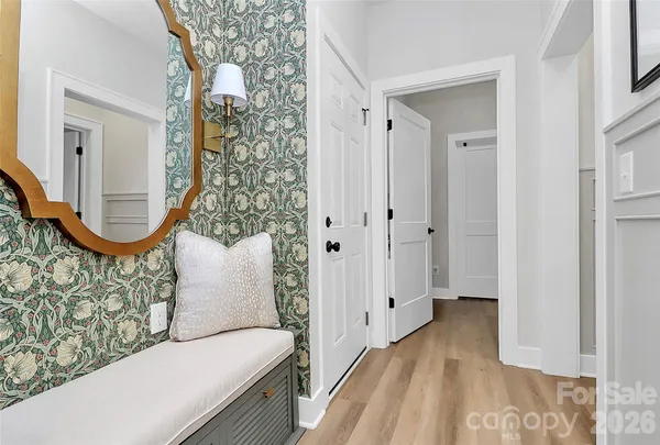 a view of a hallway with wooden floor and a mirror