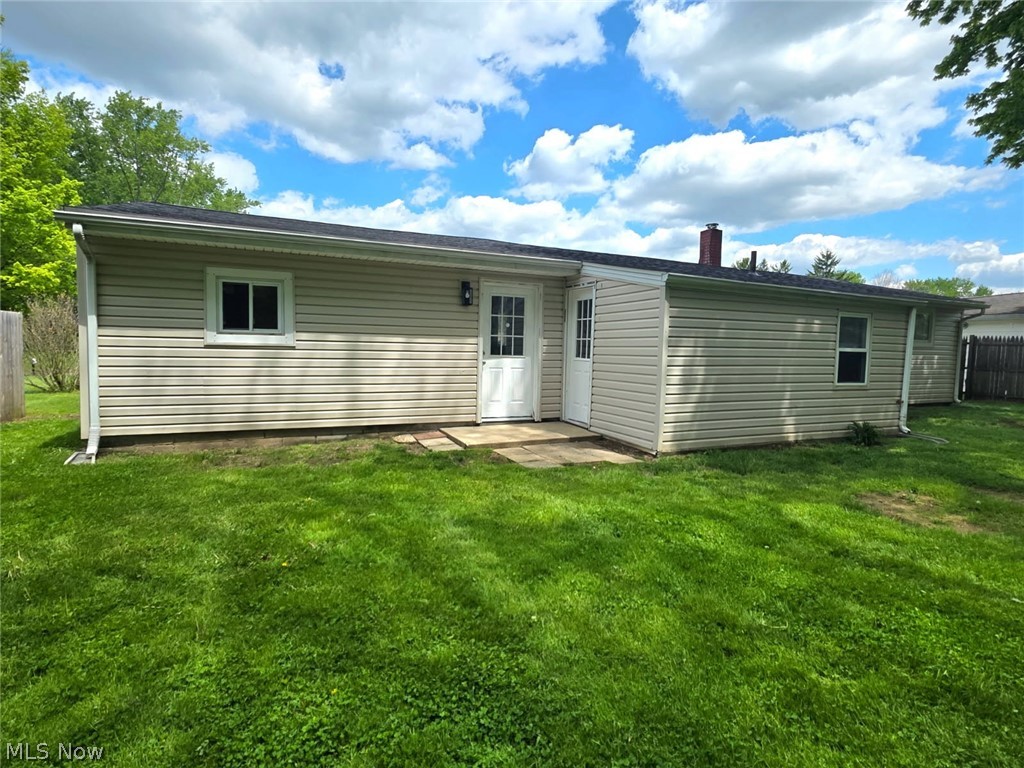 3070 Polly Road Ravenna, OH 44266 - Photo 37 of 38 Rear exterior featuring tan horizontal siding, white trim windows, and two white entry doors