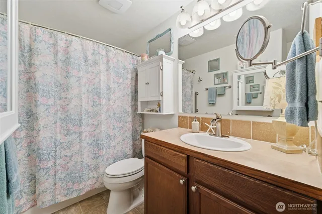 a bathroom with a sink a toilet and a mirror