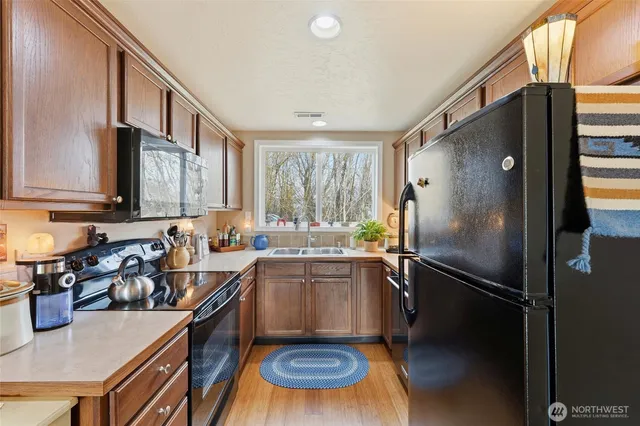 a kitchen with a refrigerator a sink and a stove top oven